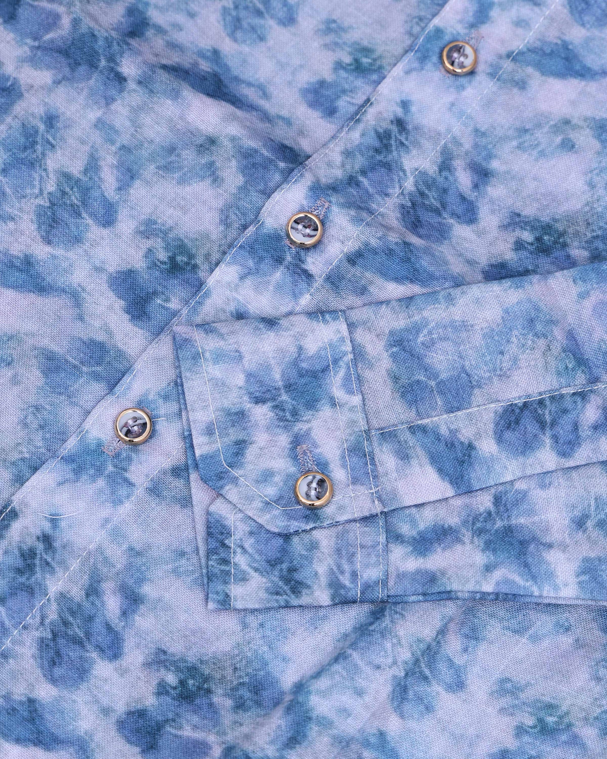 Close-up of a blue tie-dye shirt with buttons and a pocket.