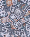 Close-up of a shirt with tribal pattern in blue, orange, and white.