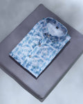 Folded blue floral shirt on a gray surface