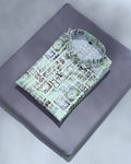 Folded shirt with green geometric pattern on a gray surface