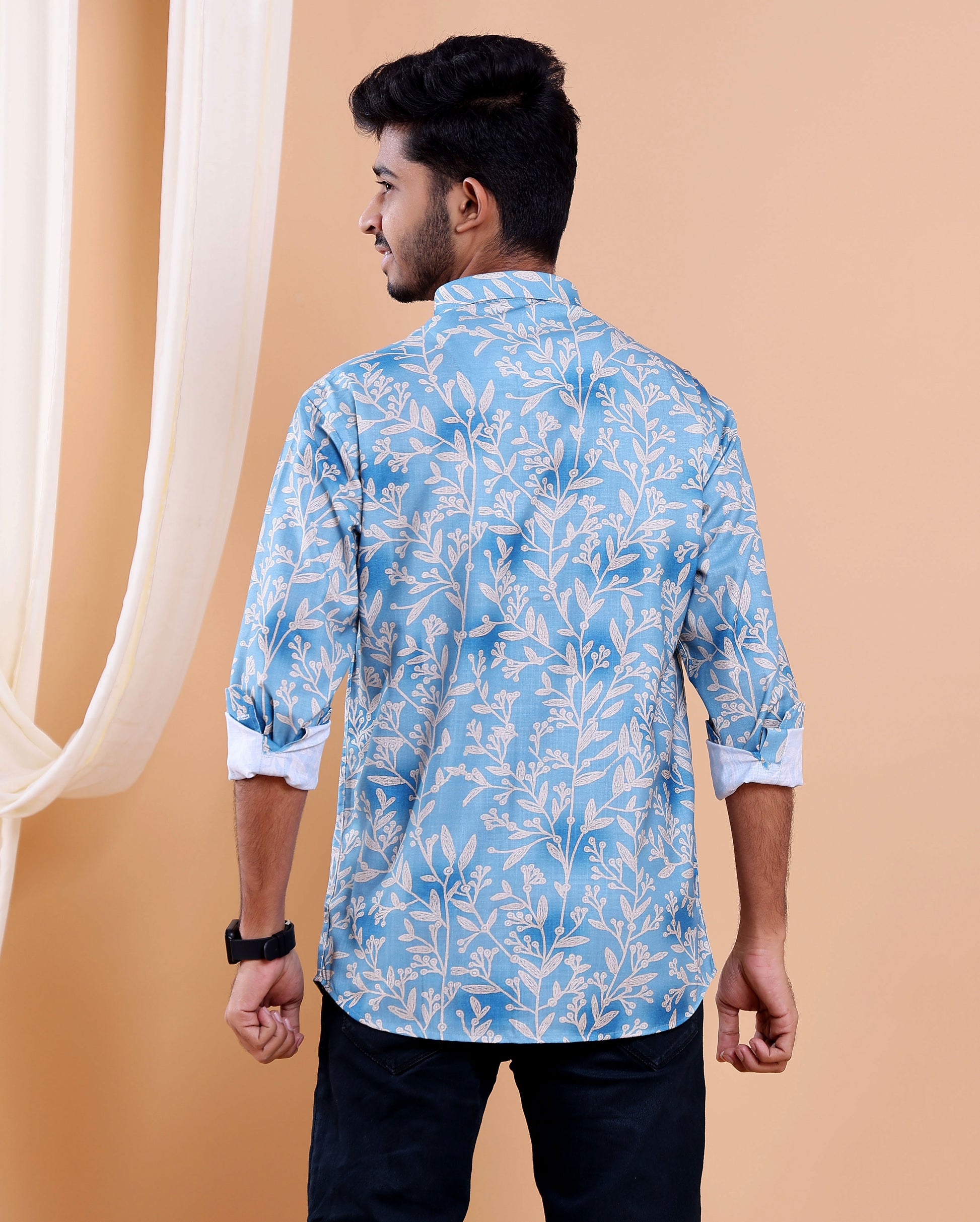 Man wearing a blue floral patterned shirt against a beige background