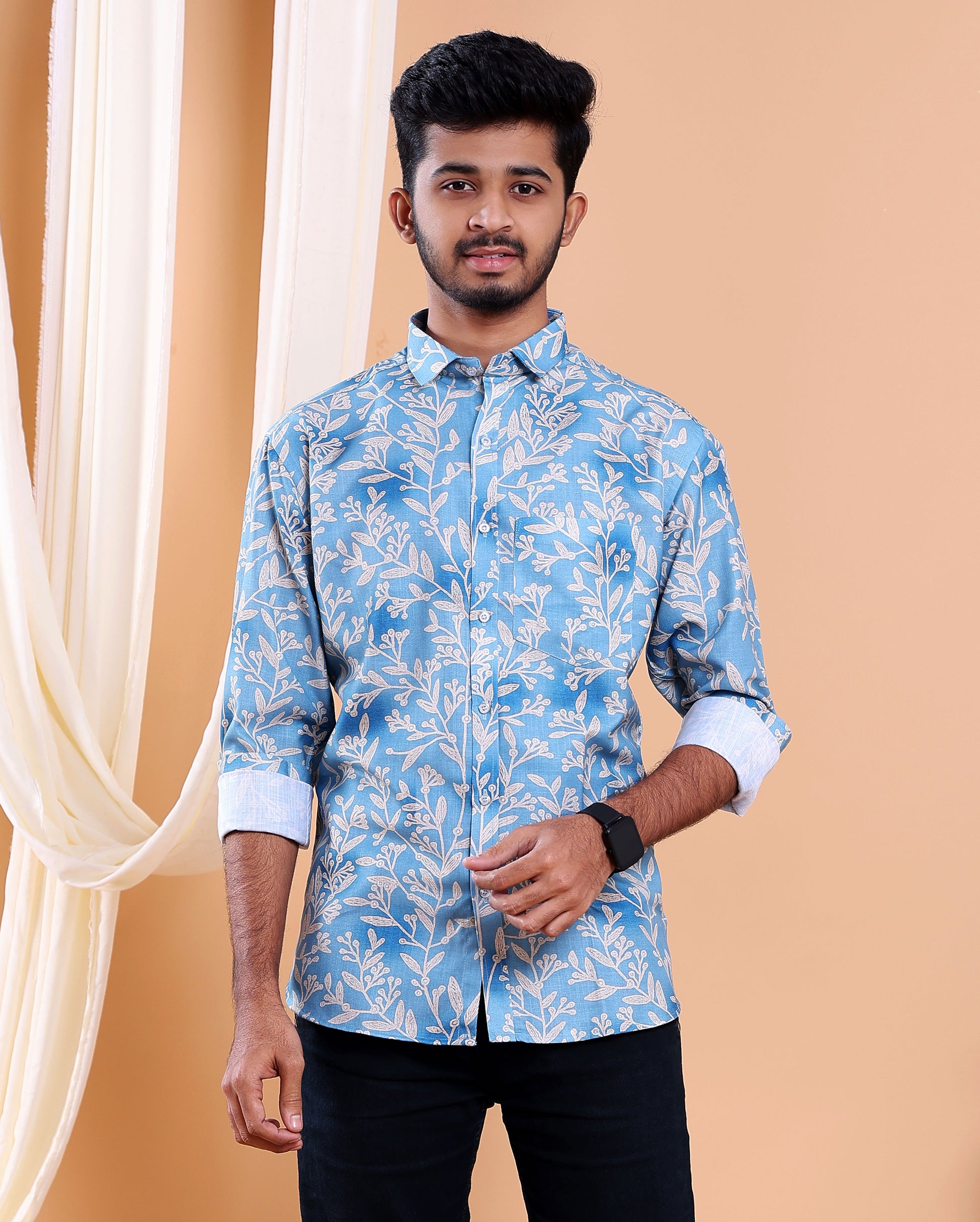 Man wearing a blue floral patterned shirt against a beige background
