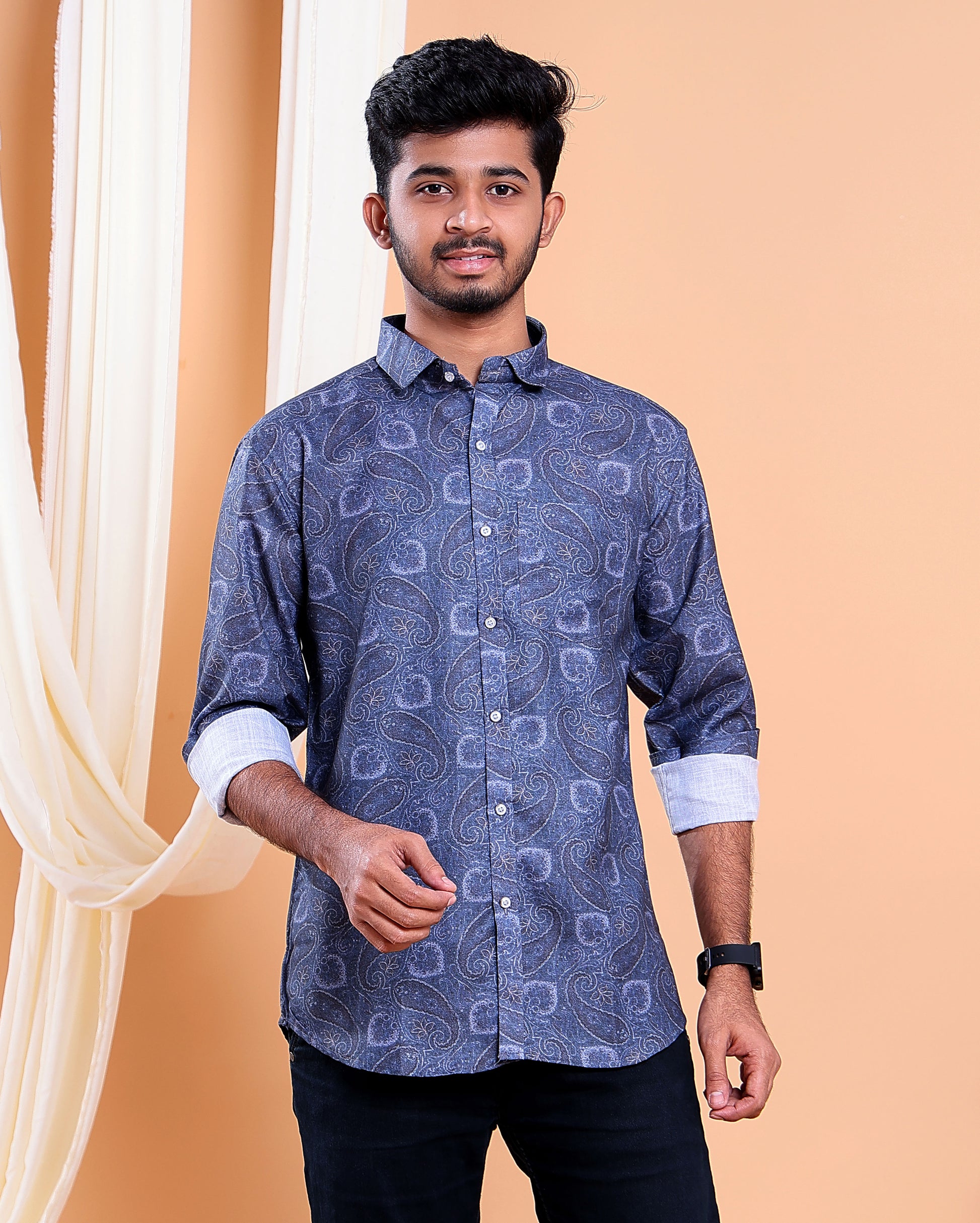 Man wearing a blue patterned shirt against a beige background