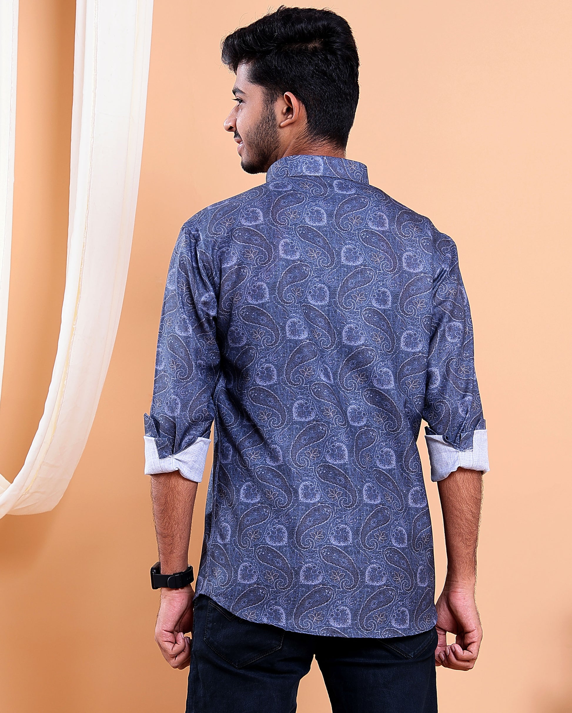 Man wearing a blue patterned shirt against an orange background
