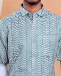 Man wearing a green and white patterned shirt against a beige background