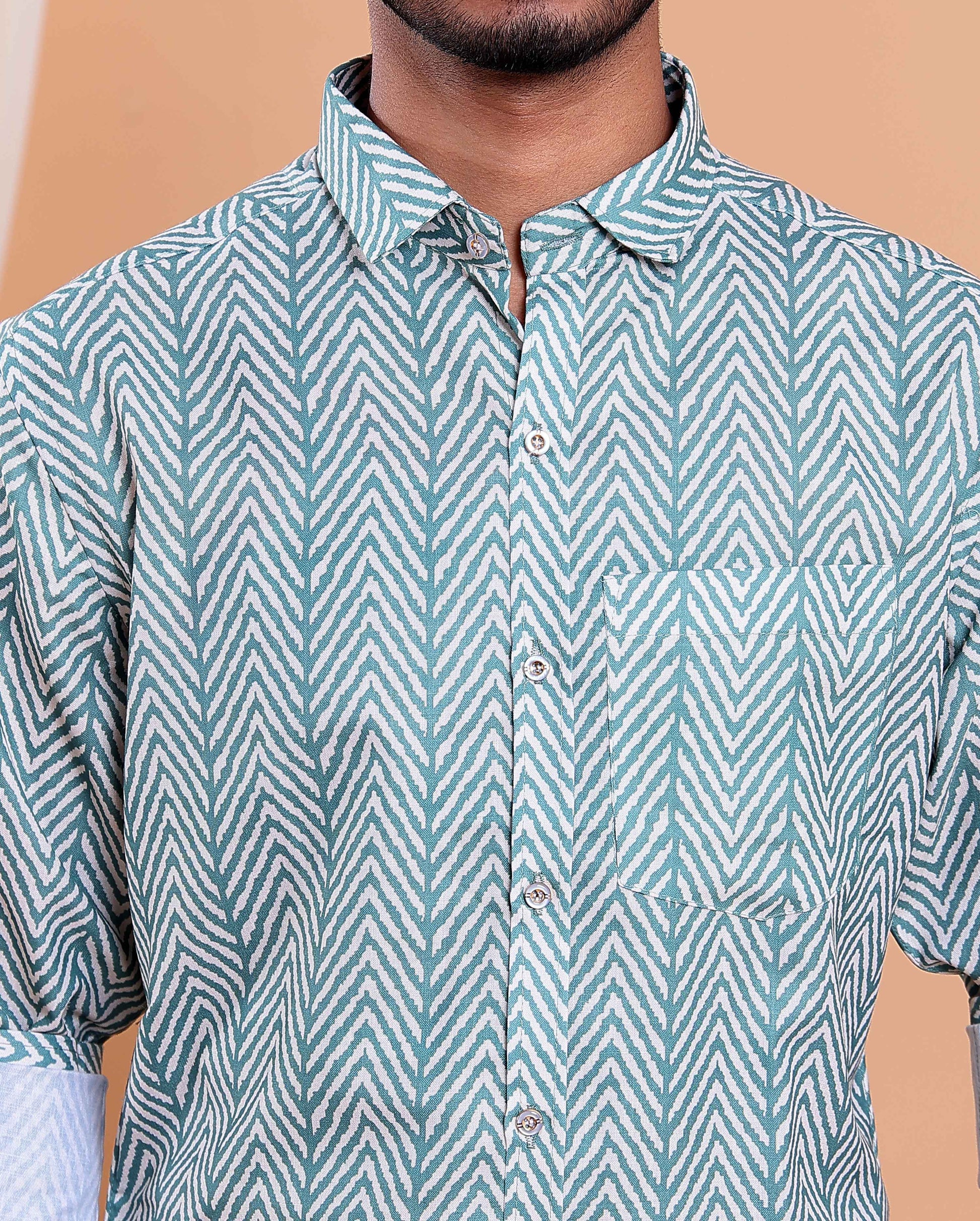 Man wearing a green and white patterned shirt against a beige background