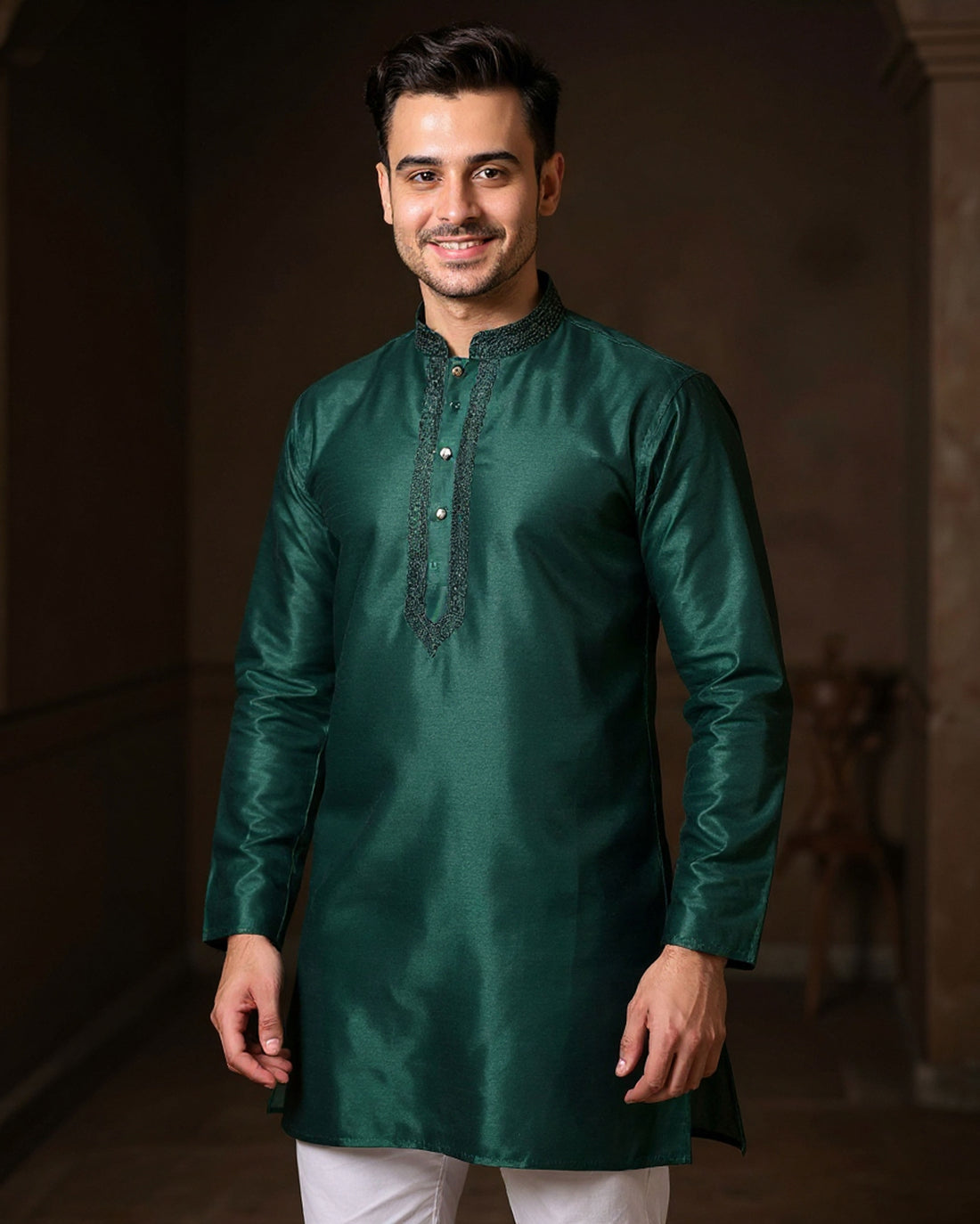 Man wearing a green kurta with white pants against a dark background