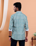 Man wearing a green patterned shirt against an orange background