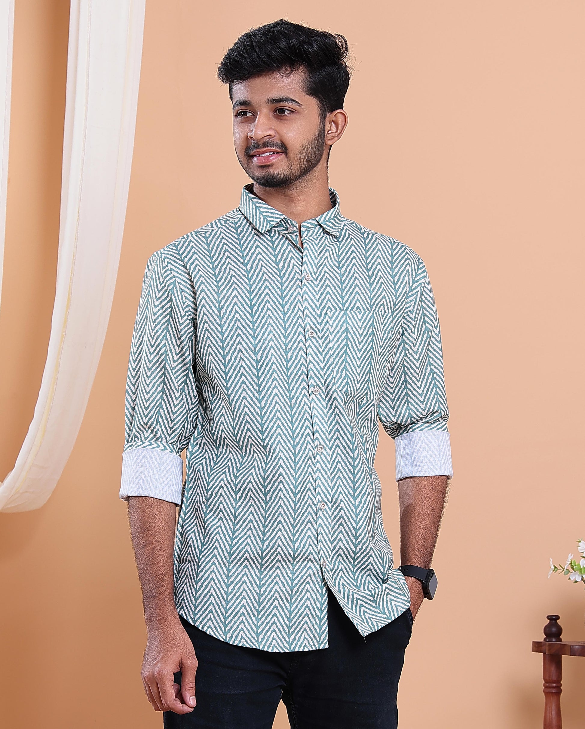 Man wearing a patterned shirt against a beige background