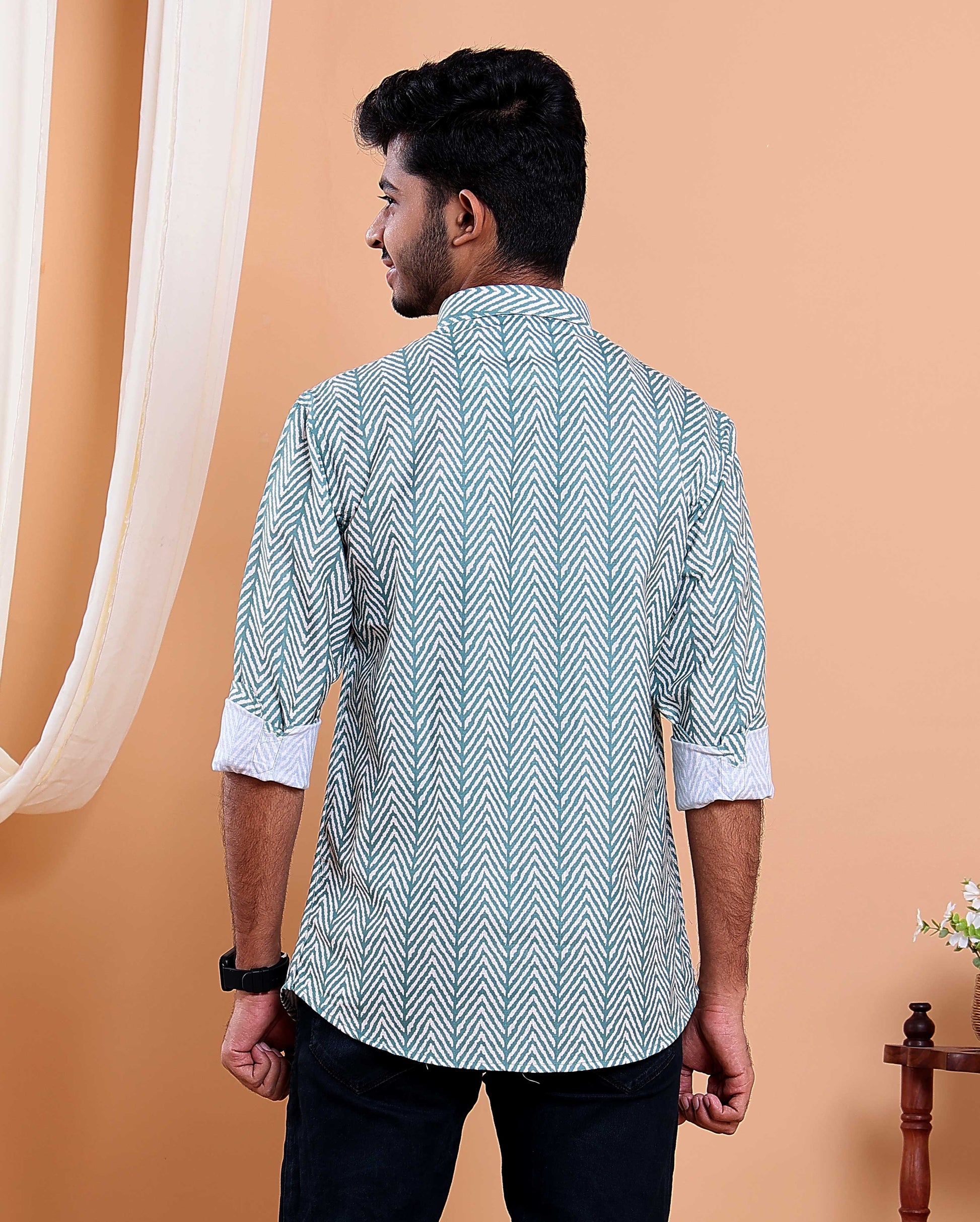 Man wearing a patterned shirt against an orange background