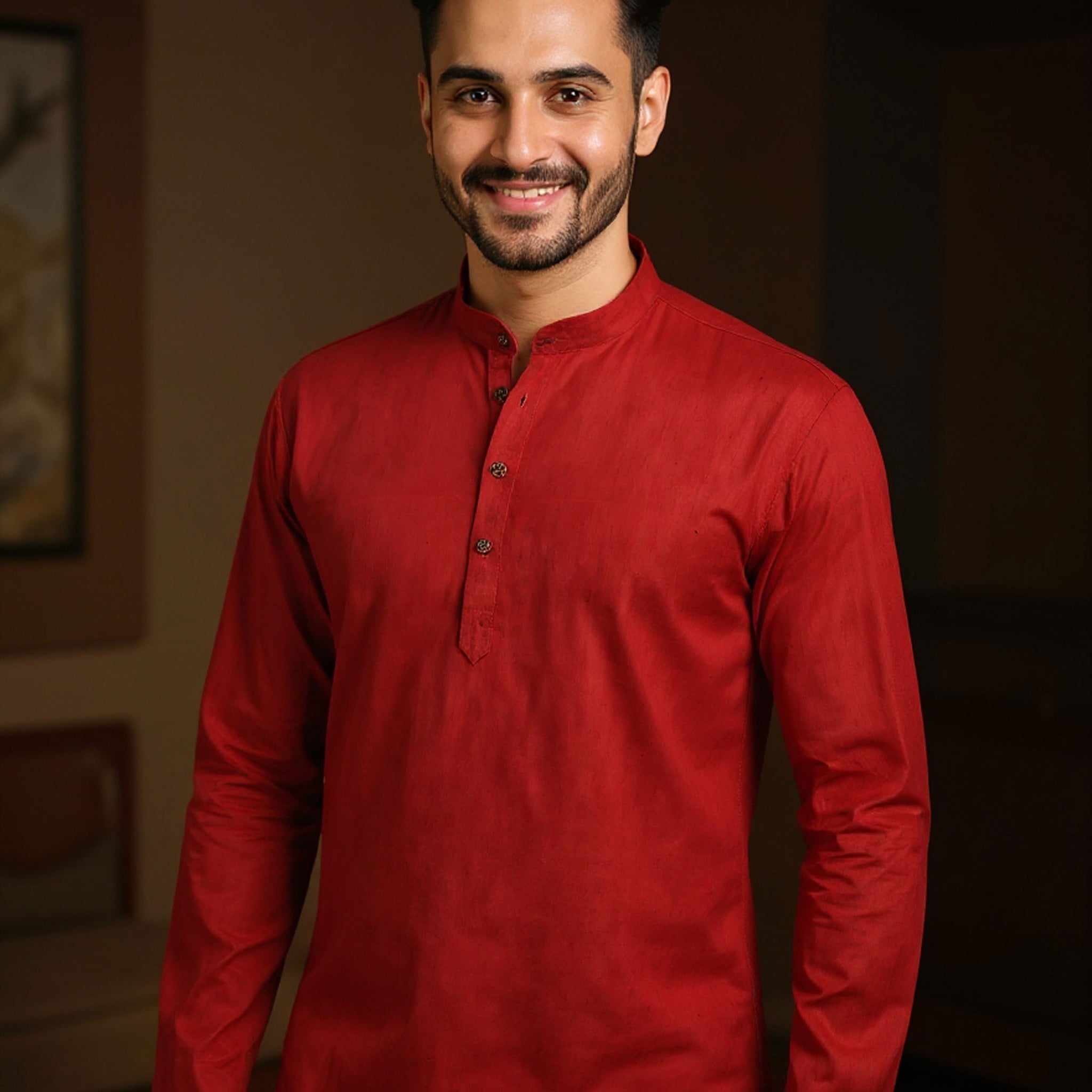 Man wearing a red kurta with white pants indoors
