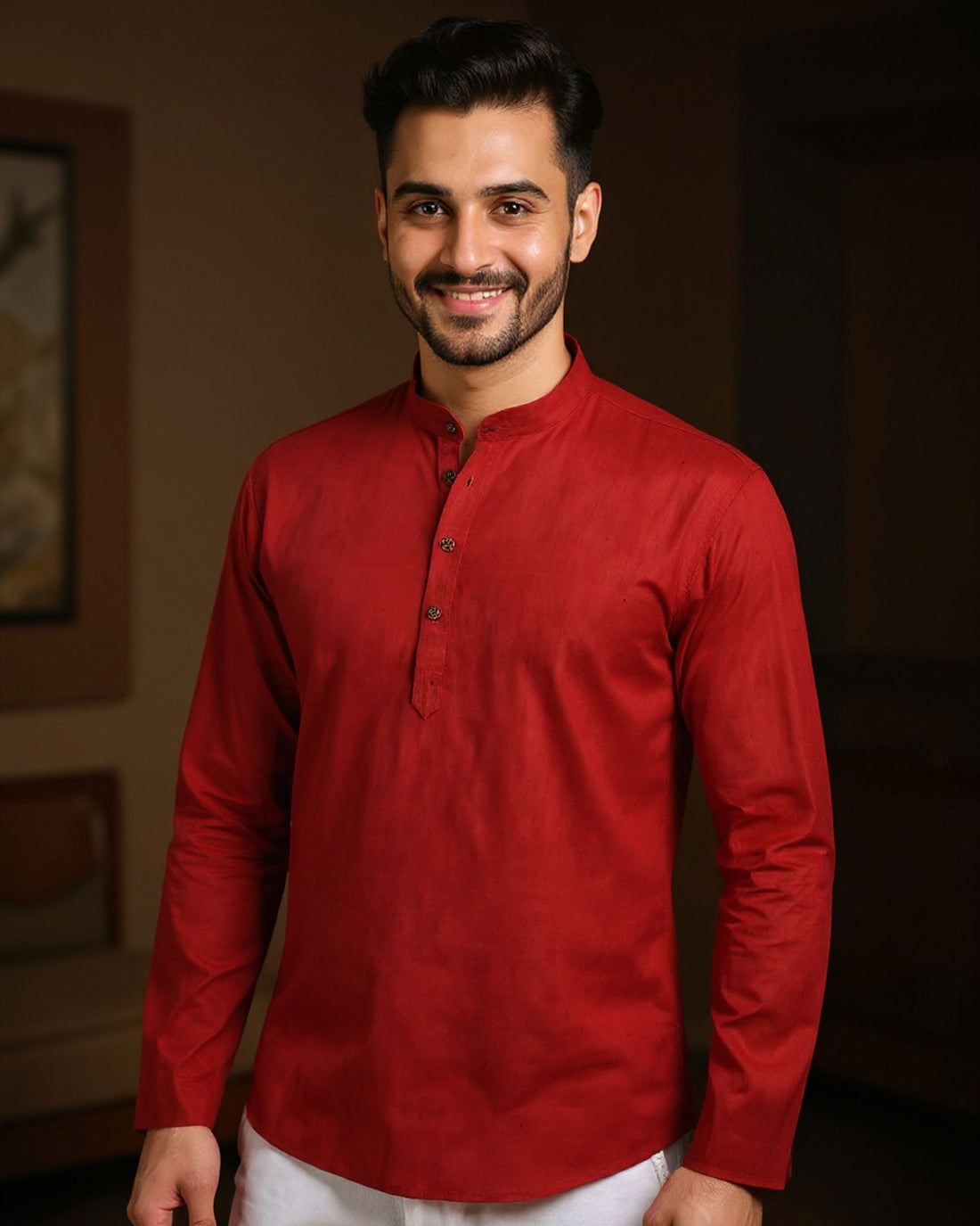 Man wearing a red kurta with white pants indoors