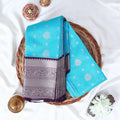 Elampillai silk cotton saree with silver zari floral motifs and broad contrast zari border in blue top view