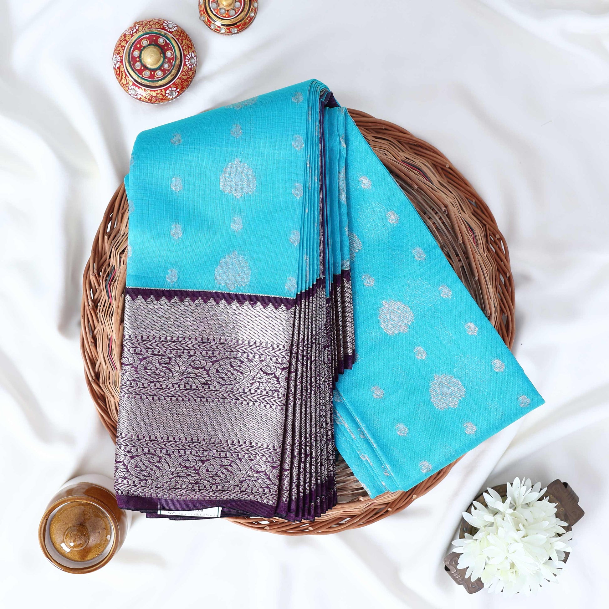 Elampillai silk cotton saree with silver zari floral motifs and broad contrast zari border in blue top view