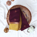 Dark Purple Elampillai silk cotton saree with gold zari buttas and contrast zari border, folded top view.