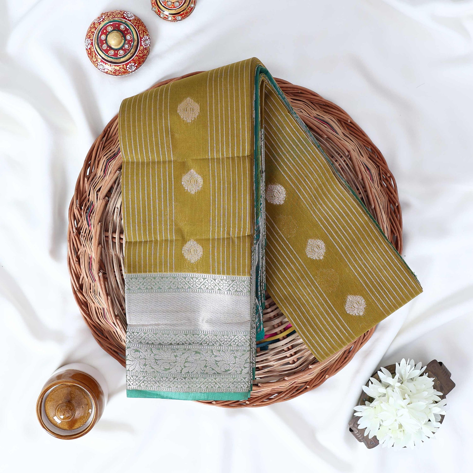 Olive Green Elampillai silk cotton saree with zari buttas vertical stripes and silver zari border folded top view
