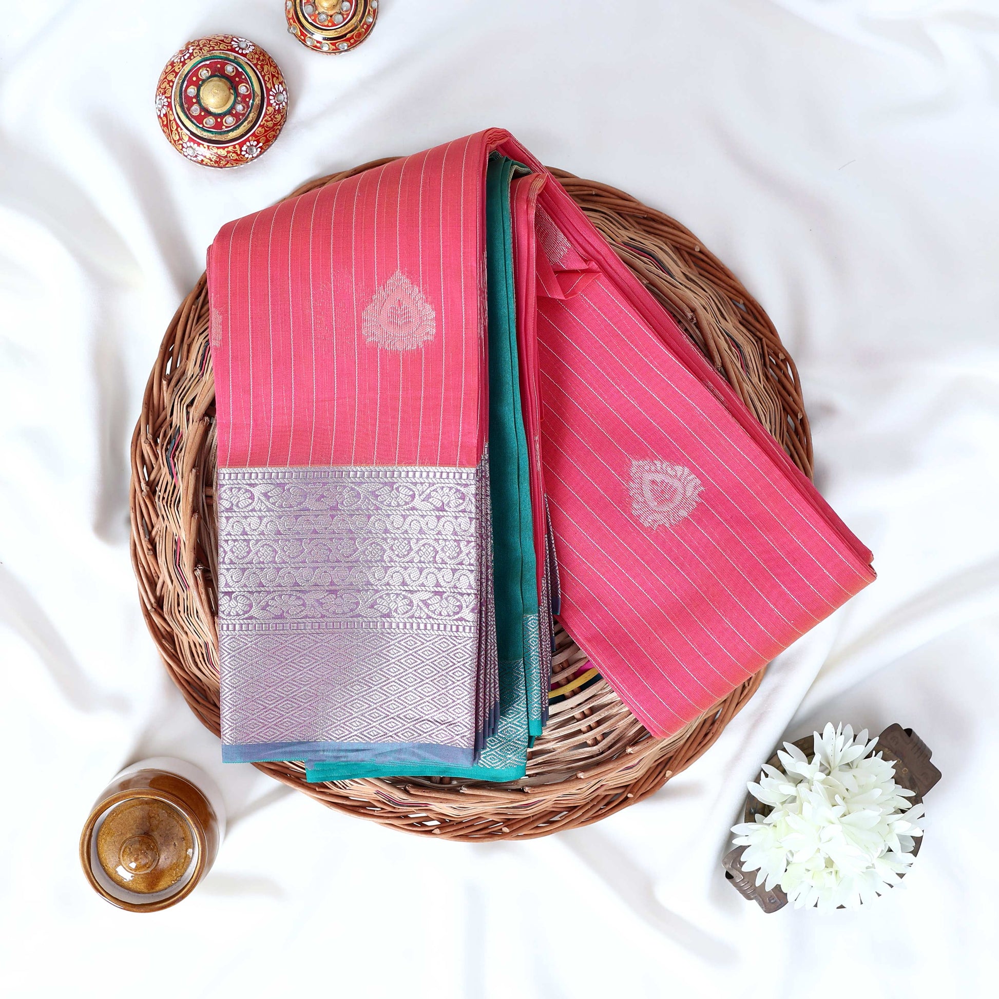 Pink Elampillai silk cotton saree with silver zari floral buttas vertical stripes and contrast floral zari border folded top view