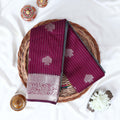 Purple Elampillai silk cotton saree with silver zari floral buttas, vertical stripes and contrast floral zari border folded top view