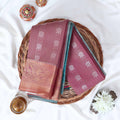 Purple Elampillai silk cotton saree with silver floral zari buttas, vertical stripes and contrast zari border folded top view