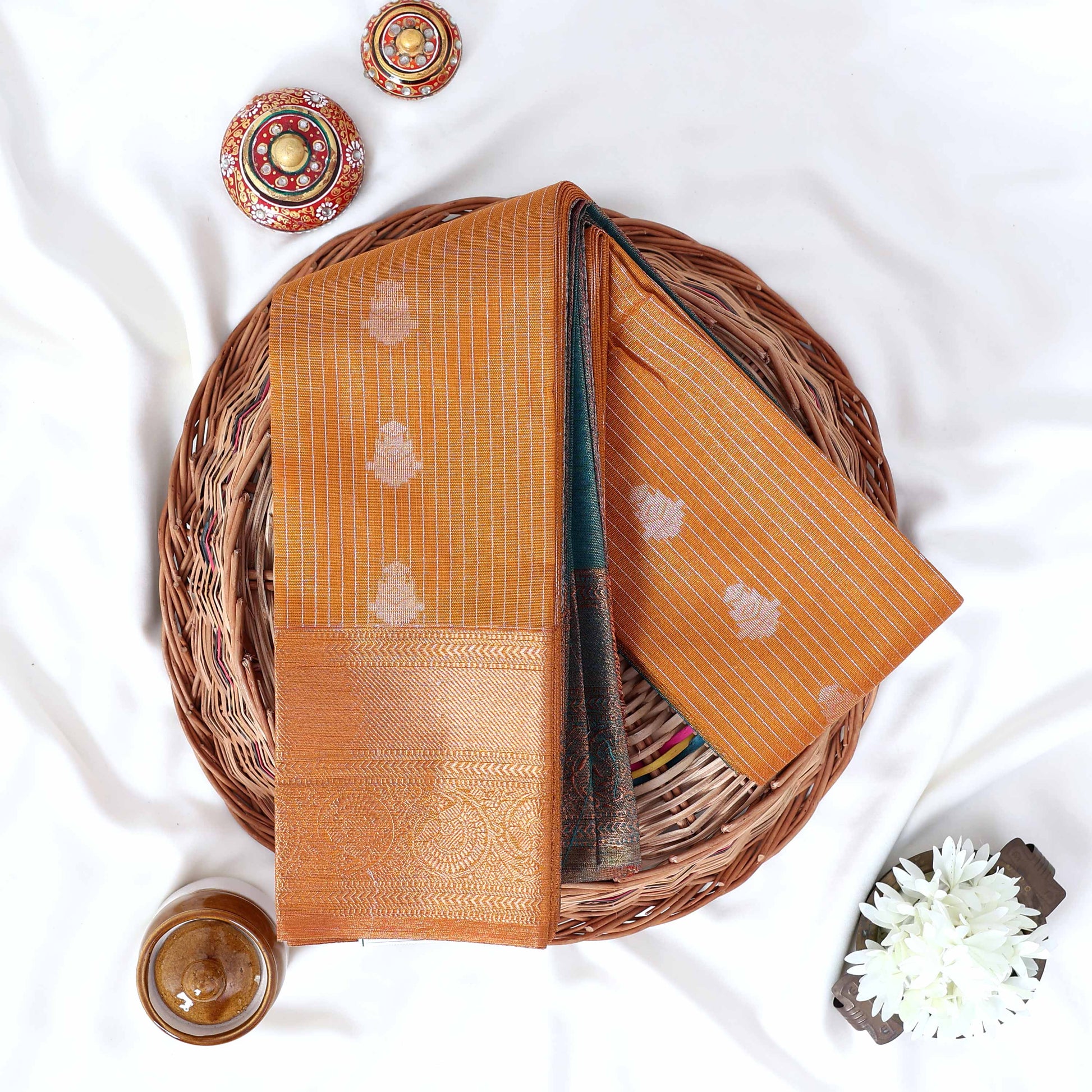 Yellow Elampillai silk cotton saree with silver floral zari buttas, vertical stripes and contrast zari border folded top view