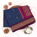 Kalyani Cotton saree with plain deep blue body and maroon zari woven border, folded top view
