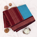 Kalyani Cotton saree with sky blue body and maroon zari woven border, folded top view