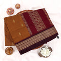 Kalyani Cotton saree with deep brown body and maroon zari woven border, folded top view