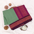 Kalyani Cotton saree with green  checked body and purple zari woven border, folded top view