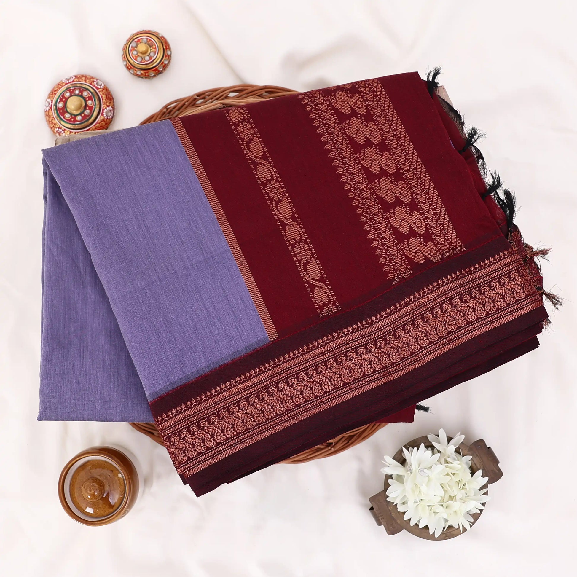Kalyani Cotton saree with lavender body and maroon zari woven border, folded top view