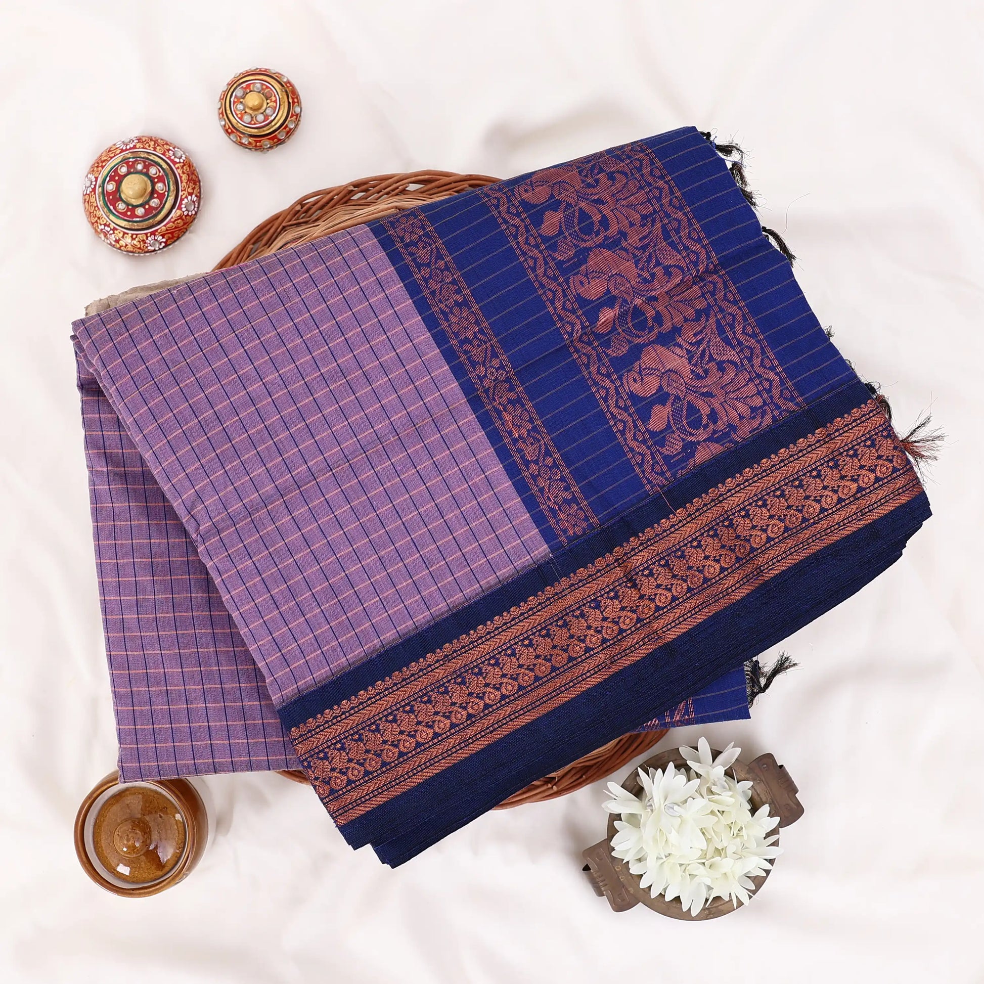 Kalyani Cotton saree with lavender  checked body and blue zari woven border, folded top view