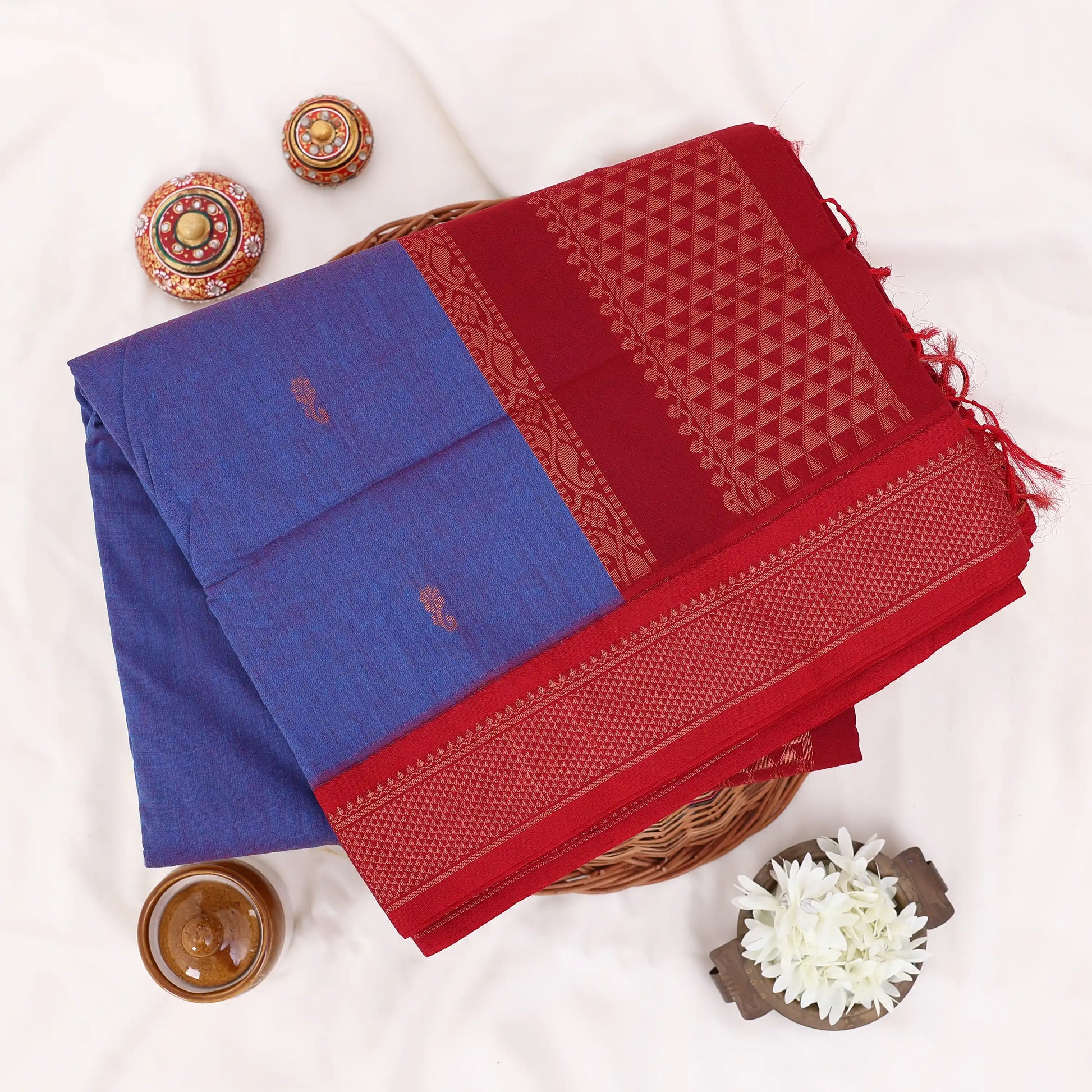 Kalyani Cotton saree with deep violet body and red zari woven border, folded top view