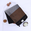 Khadi cotton saree with contrast woven border and tassels in black folded flat lay product view.