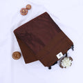 Khadi cotton saree with contrast woven border and tassels in brown folded flat lay product view.