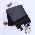 Khadi cotton saree with contrast woven border and tassels in dark brown folded flat lay product view.