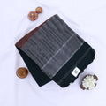 Khadi cotton saree with contrast woven border and tassels in dark green folded flat lay product view.