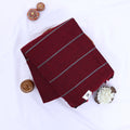 Khadi cotton saree with silver woven stripes maroon color and tassel detail folded flat lay product view.
