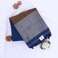 Khadi cotton saree with contrast woven border and tassels in blue folded flat lay product view.
