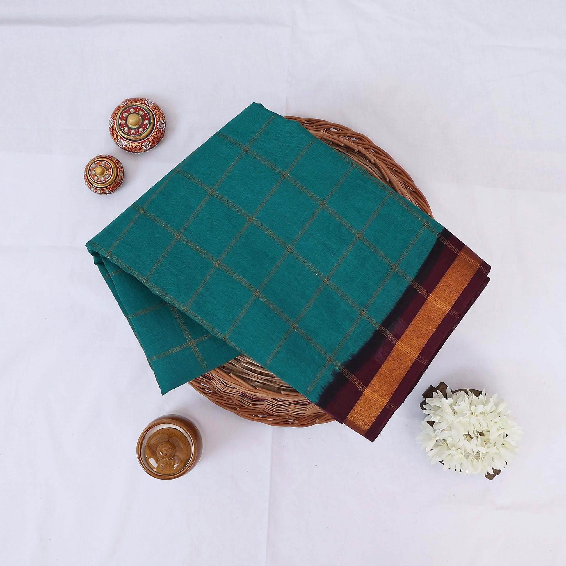 Sungudi cotton saree with zari checked body and contrast zari border in green and maroon folded top view 