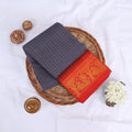 Sungudi cotton saree with gold zari checks body and red peacock motif border folded top view on wicker basket