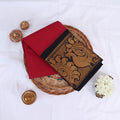 Sungudi cotton saree with gold zari floral border in red and black folded on wicker basket top view