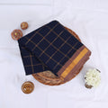 Sungudi cotton saree with zari checked body and contrast zari border in navy blue and brown folded top view 