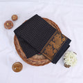 Sungudi cotton saree with gold zari checks body and blue peacock motif border folded top view on wicker basket