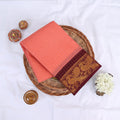 Sungudi cotton saree with gold zari checks body and maroon peacock motif border folded top view on wicker basket