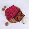 Pink Sungudi cotton saree with floral and ikat inspired motif print and maroon Contrast zari border folded top view