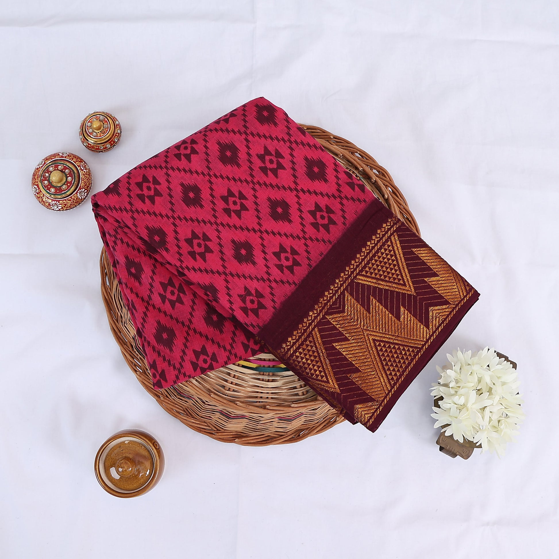 Pink Sungudi cotton saree with floral and ikat inspired motif print and maroon Contrast zari border folded top view