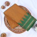Venkatagiri cotton saree with a light brown body green contrast zari border and butta motifs top folded view.