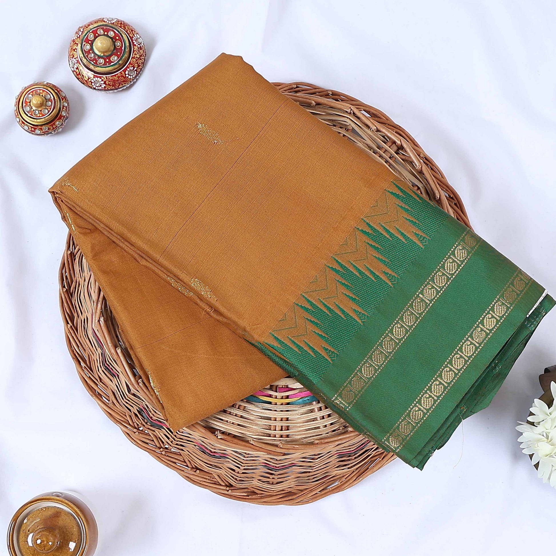 Venkatagiri cotton saree with a light brown body green contrast zari border and butta motifs top folded view.