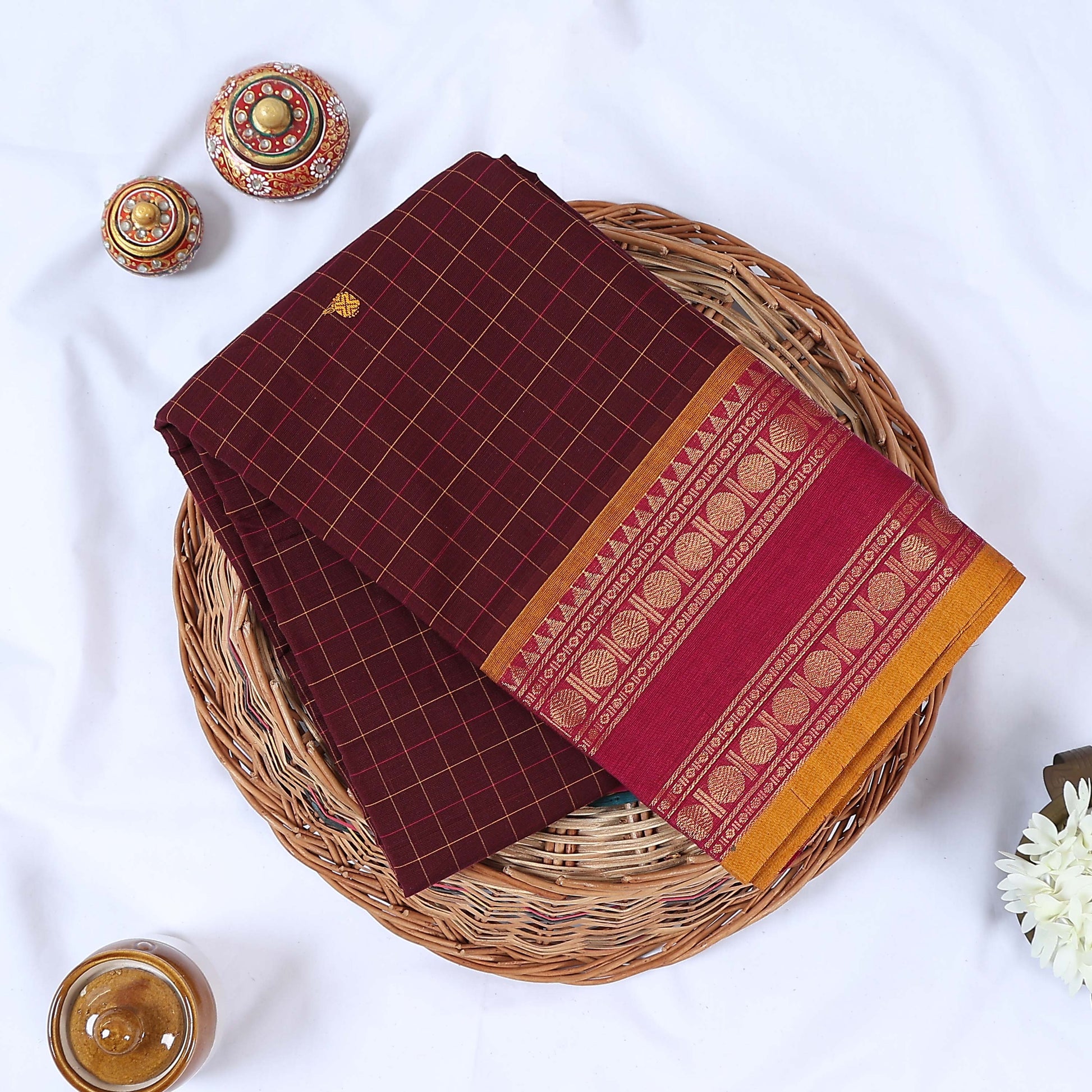 Venkatagiri cotton saree with brown checked body and pink gold zari border folded flat lay view