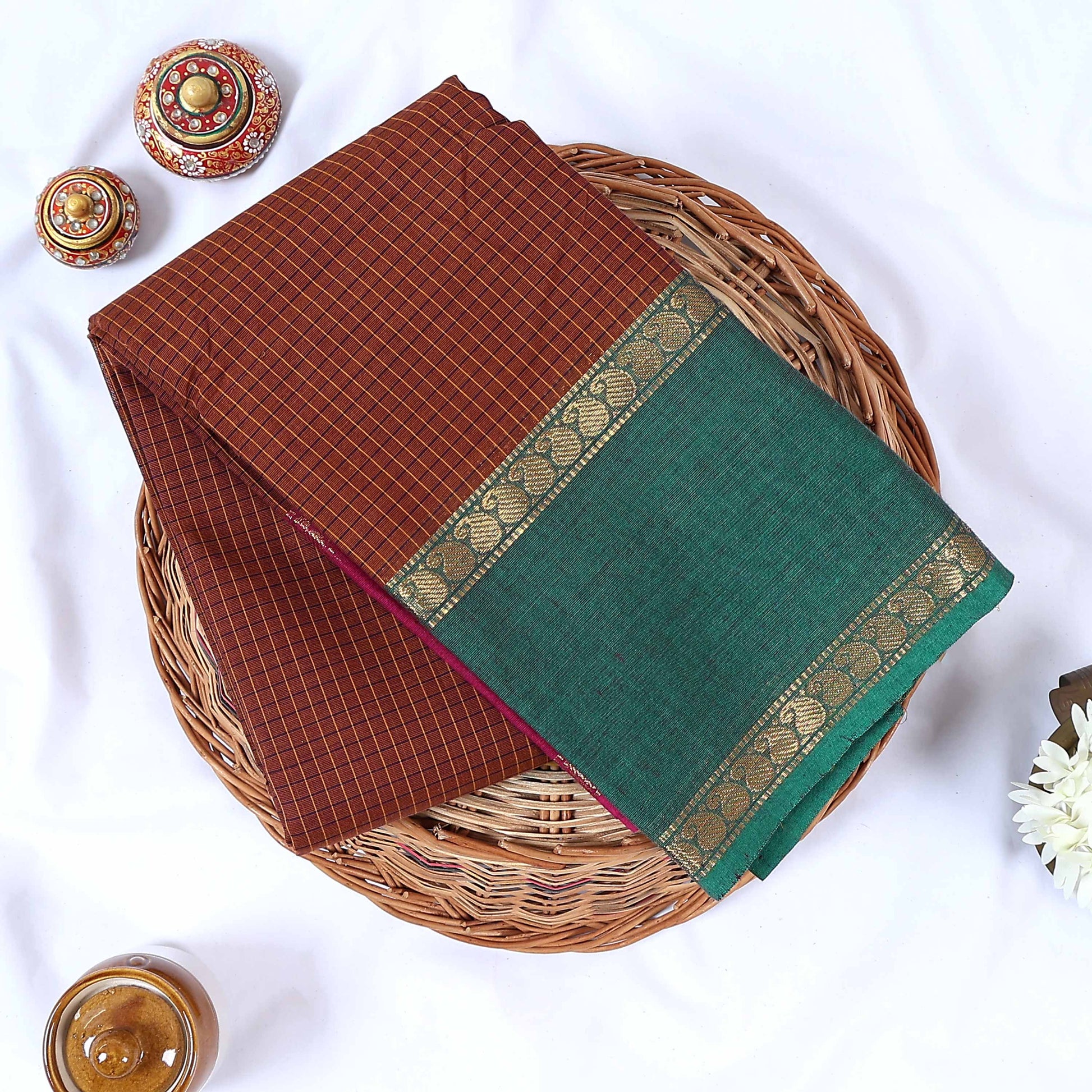 Top view of brown Venkatagiri cotton saree with checks green contrast border and gold zari motifs.