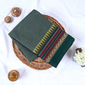 Dark green Venkatagiri cotton saree with multicolor geometric zari woven border folded flat lay front view.